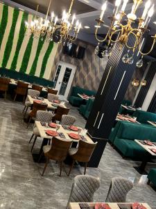 a restaurant with tables and chairs and a chandelier at MaxWell Hotel & SPA in Tashkent