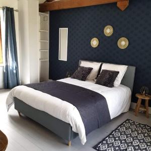 1 dormitorio con 1 cama grande y pared azul en L'Echappée Belle, en Marciac