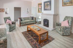 a living room with two couches and a fireplace at Koo Karoo Guest Lodge and Self Catering in Montagu