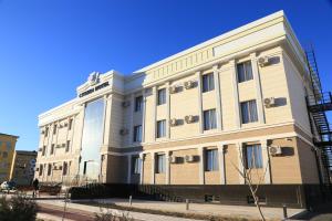 a large white building on a city street at CITIZEN HOTEL in Nukus