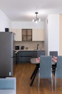 cocina con mesa, sillas y nevera en Apartments in the Terra residential complex 15, en Almaty