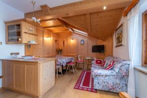 a living room with a kitchen and a dining room at Ciasa Pelin in Moena