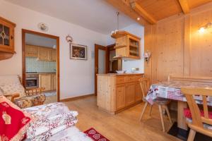 a kitchen and living room with a table and a dining room at Ciasa Pelin in Moena