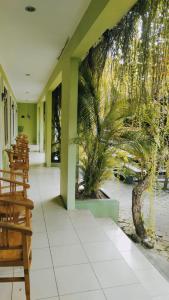 a lobby of a restaurant with a palm tree mural at PURNAMA HOUSE KUTA in Kuta