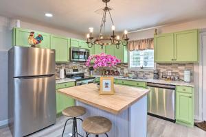 a kitchen with green cabinets and a refrigerator at Cedar Creek Escape with Gas Grill and Fire Pit! in Tool