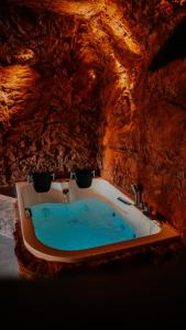 a bath tub in a cave with blue water at Love Cottage mit Whirlpool in Hagen