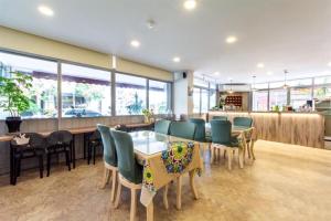 un restaurante con mesa, sillas y ventanas en Guan Lun Hotel en Hualien