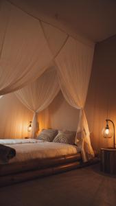 a bedroom with a canopy bed with white drapes at Love Cottage mit Whirlpool in Hagen