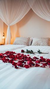a pile of red roses on a bed at Love Cottage mit Whirlpool in Hagen