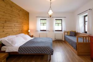 1 dormitorio con 1 cama y pared de madera en Elizabeth Cottage Benczúrfalva, en Szécsény