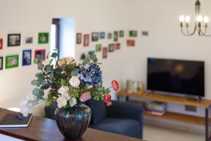un jarrón de flores sobre una mesa en la sala de estar en Elizabeth Cottage Benczúrfalva, en Szécsény