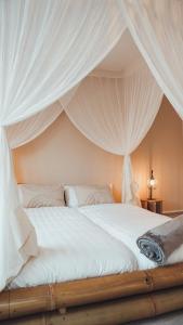 a bedroom with a bed with white drapes at Love Cottage mit Whirlpool in Hagen