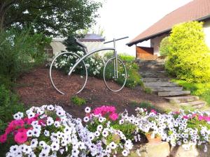 a bike in the middle of a garden with flowers at Schmidt`s Eppelborner Ferienwohnung in Eppelborn