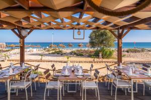 a restaurant with tables and chairs on the beach at Vincci Marillia in Hammamet