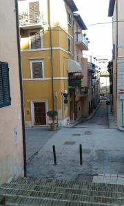 an empty street with a yellow building at Casa Paola in Spoleto