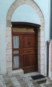 uma grande porta de madeira com uma arcada num edifício em Casa Paola em Spoleto