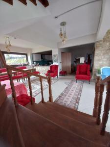 ein Wohnzimmer mit roten Stühlen und einer Treppe in der Unterkunft Hayat Oksijen Resort in Altınordu
