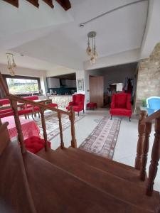 a living room with red chairs and a staircase at Hayat Oksijen Resort in Ordu