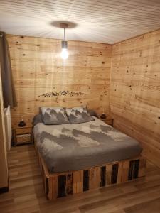 ein Schlafzimmer mit einem Bett in einem Zimmer mit Holzwänden in der Unterkunft Ha Py Chalet in Campan