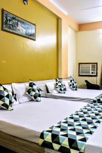 two beds in a room with yellow walls at Maruti Group of Hotels - Shree Ram Darshan in Nāthdwāra