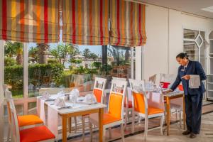 a man standing at a table in a restaurant at Vincci Marillia in Hammamet