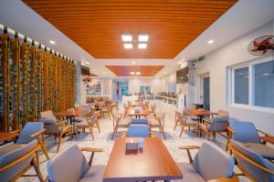 a restaurant with wooden tables and chairs in a room at Summer Dream Hotel in Phú Quốc