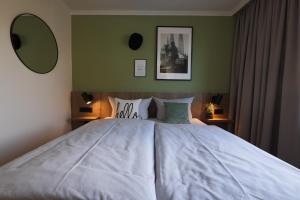 a bedroom with a large bed with white sheets at LIHO - einfach Lübeck in Lübeck