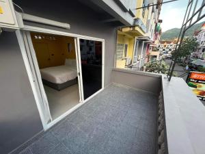 a small balcony with a bed and a window at Sari Boutique hotel in Patong Beach