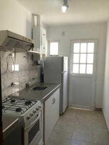 a kitchen with a stove and a refrigerator at Calido y centrico monoambiente in Concordia