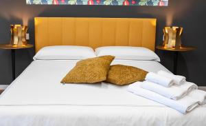 un letto bianco con due cuscini e asciugamani di MareLuna Rooms a Napoli