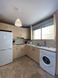 een keuken met een wasmachine en een wasmachine bij 2 Bedrooms and sofa bed flat by Wayra Tarifa in Tarifa