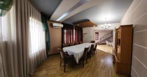 a dining room with a white table and chairs at Garda in Tashkent +9 photos