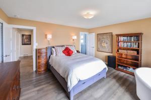 a bedroom with a bed with a red flower on it at Bazan Bay Beach House in North Saanich