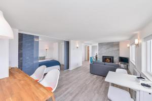 a living room with a table and chairs and a couch at Bazan Bay Beach House in North Saanich