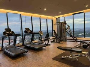 einen Fitnessraum mit Laufbändern und Crosstrainern in einem Zimmer mit Fenstern in der Unterkunft Hill 10 2r1b 3pax Double Tree I-city Hotel Grade in Shah Alam