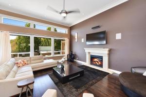 a living room with a couch and a fireplace at Nature's Gate Executive Estate in Victoria