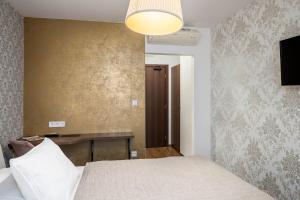 a bedroom with a bed and a desk and a lamp at Hotel MAXPLAZA in Trnava