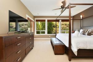 a bedroom with a canopy bed and windows at Nature's Gate Executive Estate in Victoria