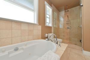 uma casa de banho com uma banheira, um chuveiro e um WC. em Nature's Gate Executive Estate em Victoria