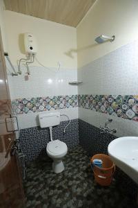 a bathroom with a toilet and a sink at The Little Prince - Mangalore Beach Homestay in Mangalore