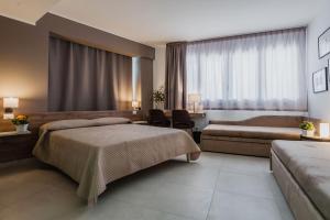 a hotel room with two beds and a couch at Archimede's Rooms in Siracusa