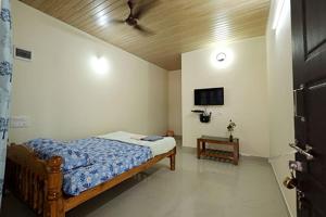 a bedroom with a bed and a ceiling fan at The Little Prince - Mangalore Beach Homestay in Mangalore