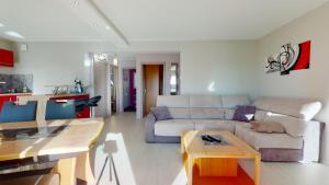 a living room with a couch and a table at Le Clos des Maraichers avec Parking in Colmar