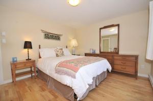 sypialnia z łóżkiem, komodą i lustrem w obiekcie Heron View Cottage w mieście Sidney