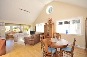 uma sala de estar com uma mesa e um sofá em Heron View Cottage em Sidney