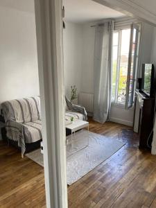 a living room with a couch and a table at Bel Appartement lumineux à 2 min du RER B in La Courneuve