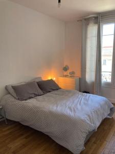 1 dormitorio con 1 cama grande y ventana en Bel Appartement lumineux à 2 min du RER B, en La Courneuve