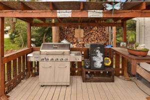 a barbecue grill on a wooden deck with a wooden pergola at Dragonfly Cottage in Nanaimo