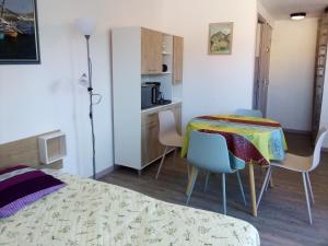 Habitación con mesa, sillas y cocina. en la Catalane en Vernet-les-Bains