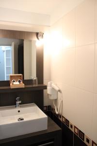 a bathroom with a white sink and a mirror at Fleur de Ré in Loix